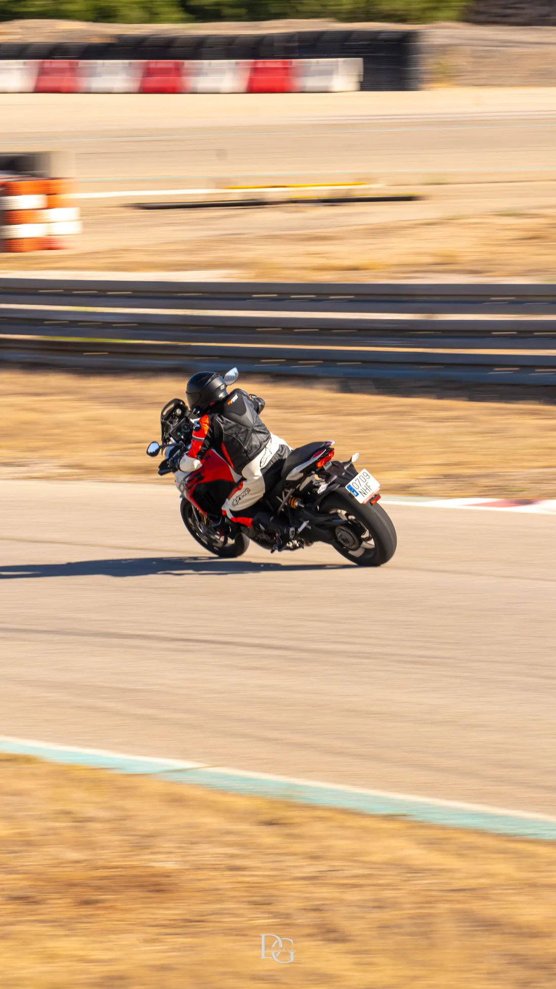 Moto negra y roja en curva con fondo de pianos