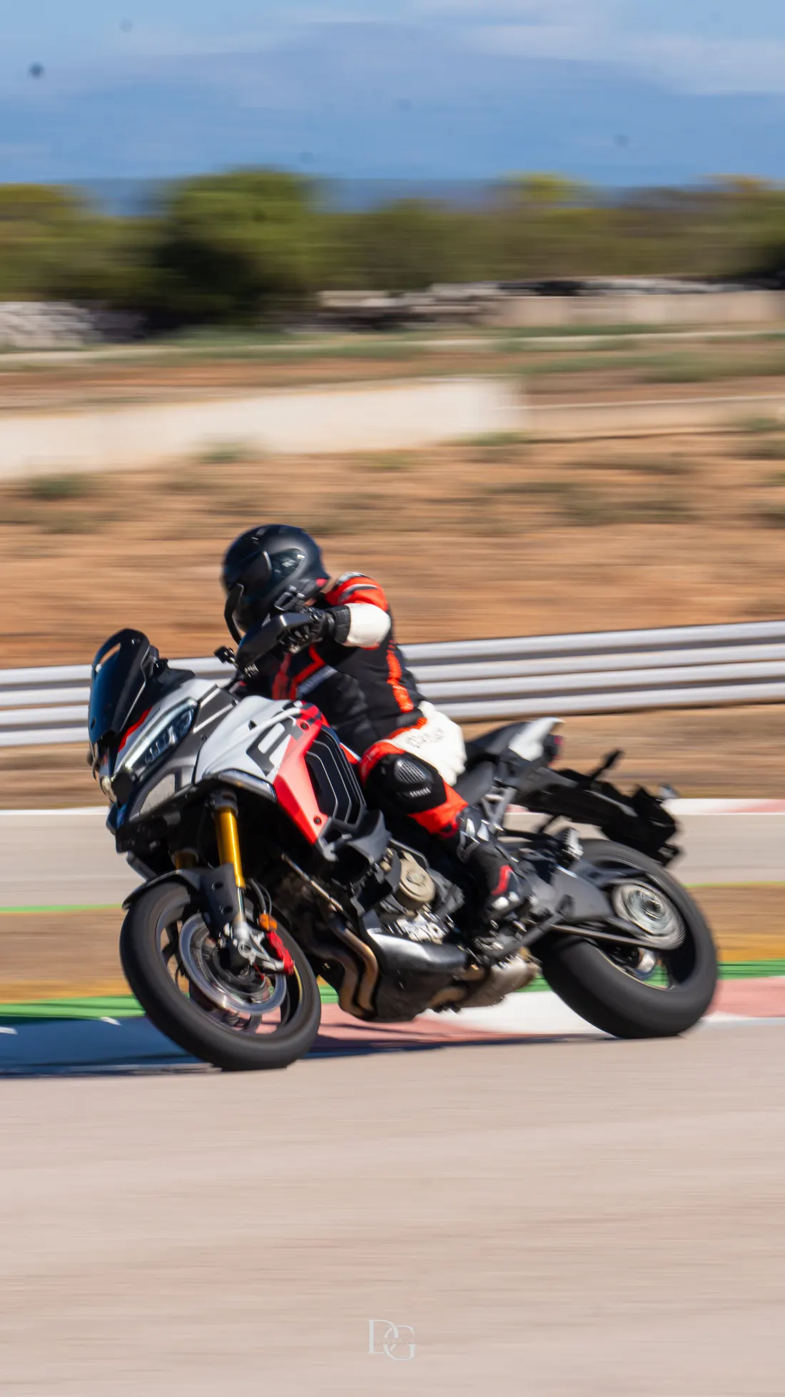 Ducati Multistrada blanca y roja inclinada en curva