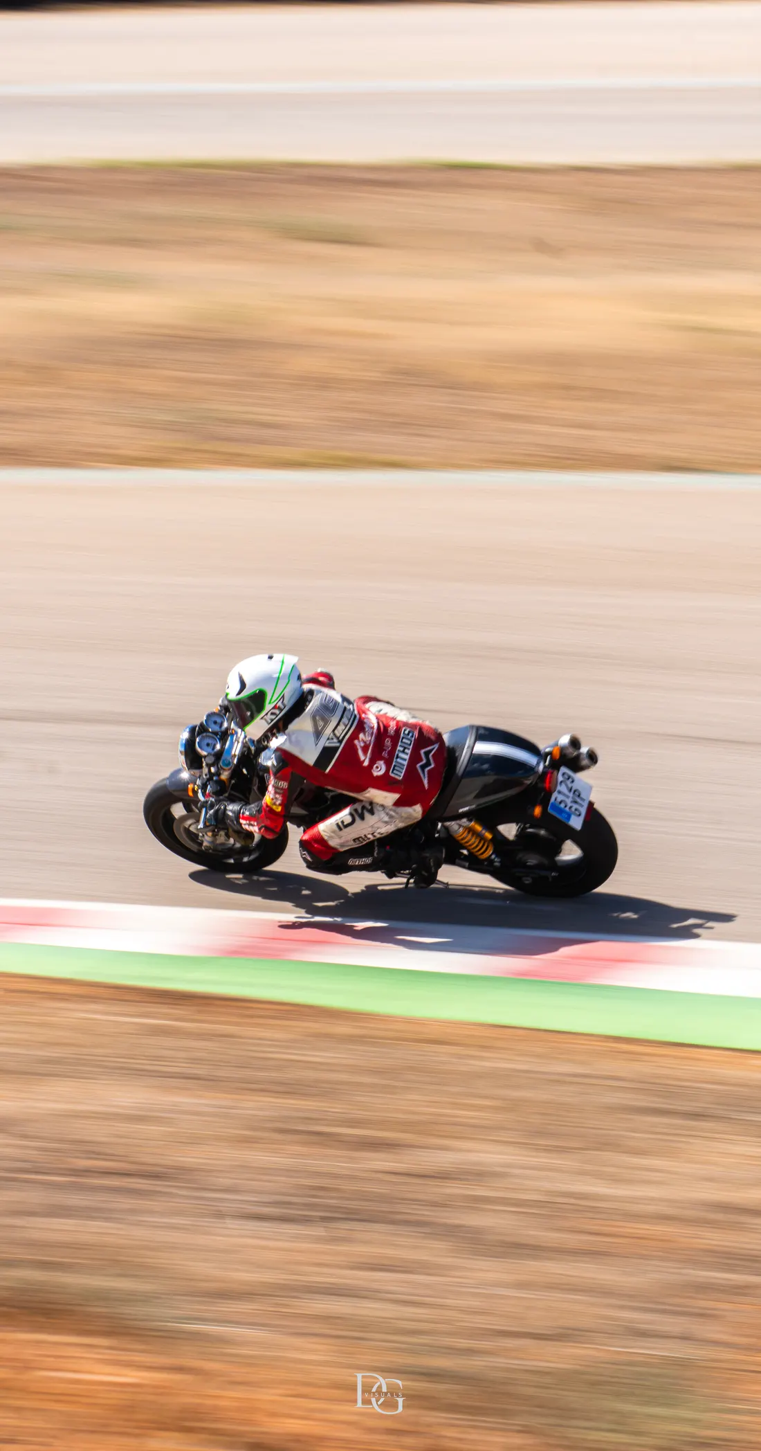 Moto roja con piloto de mono blanco rozando el piano