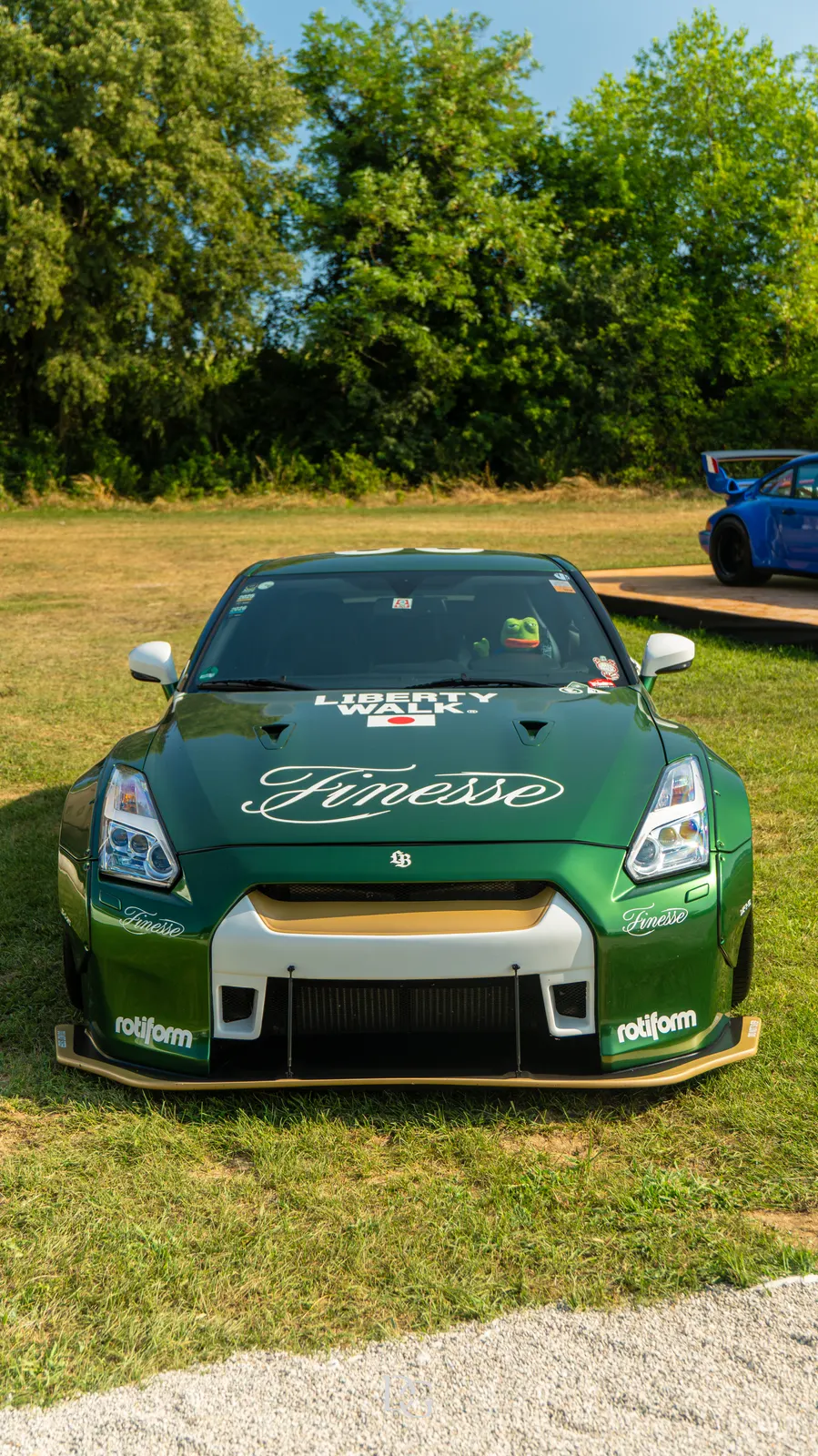 Nissan GT-R verde de frente sobre el césped