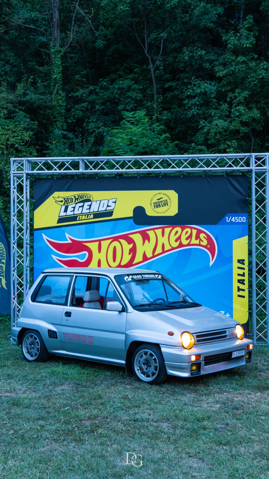 Coche compacto plateado frente a un photocall de Hot Wheels
